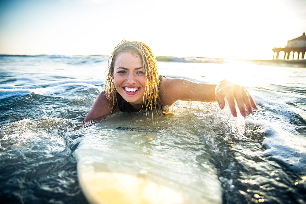Young woman surfing in San Clemente, one of the many fun things to do in OC.